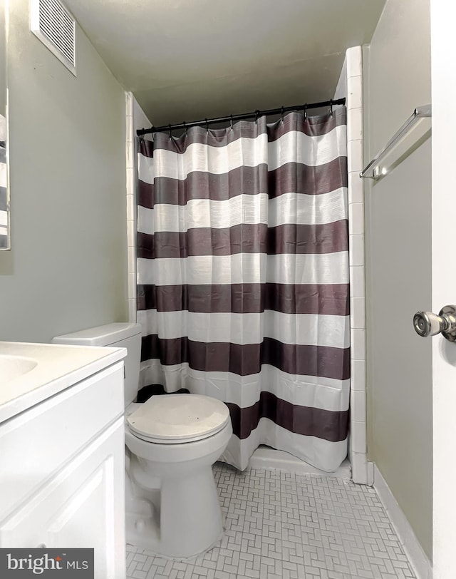 bathroom featuring a shower with shower curtain, vanity, toilet, and tile patterned floors