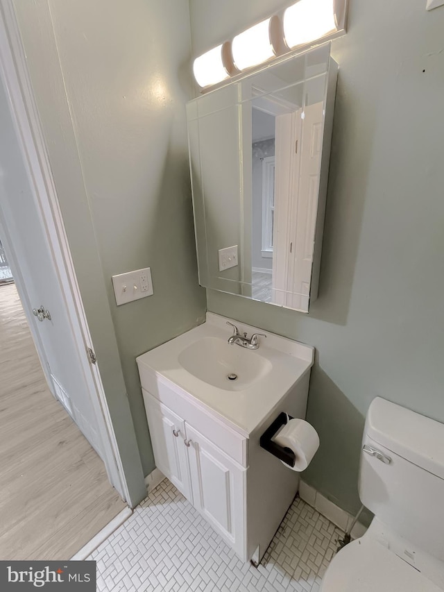 bathroom featuring vanity, wood-type flooring, and toilet