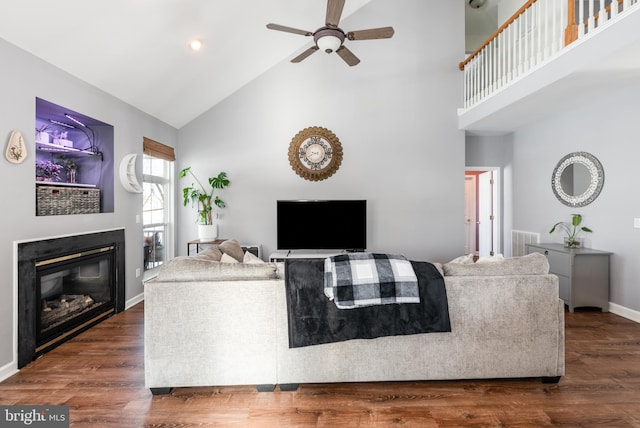 living room with dark hardwood / wood-style floors, ceiling fan, and high vaulted ceiling