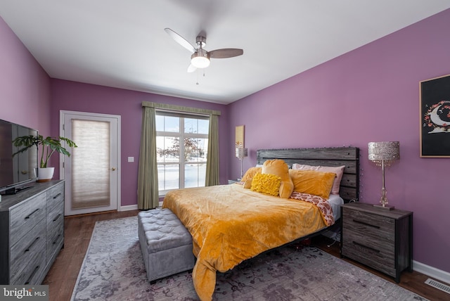 bedroom featuring access to outside, ceiling fan, and dark wood-type flooring