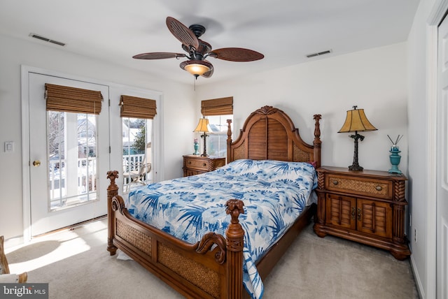 bedroom with access to outside, multiple windows, ceiling fan, and light colored carpet