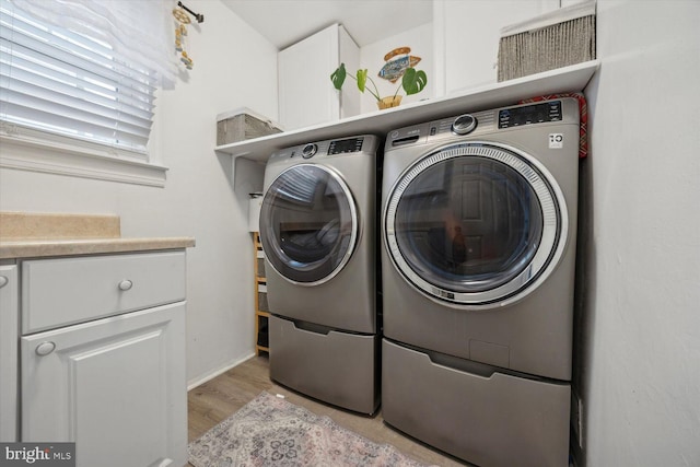 clothes washing area with light wood-type flooring and washing machine and clothes dryer