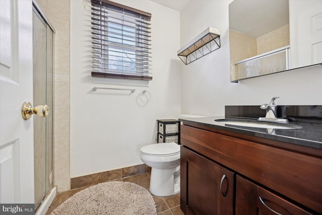 bathroom featuring tile patterned floors, vanity, an enclosed shower, and toilet