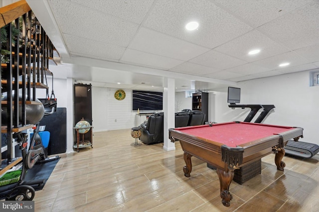 game room with a paneled ceiling, light wood-type flooring, and billiards