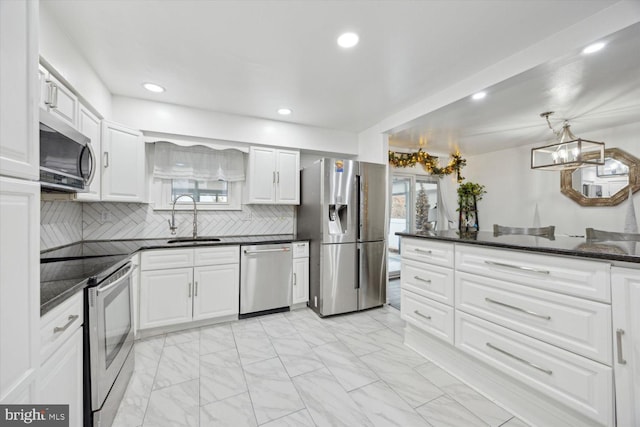 kitchen with a healthy amount of sunlight, white cabinetry, sink, and appliances with stainless steel finishes