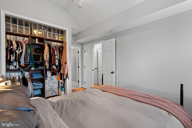 bedroom featuring a closet, wood-type flooring, and vaulted ceiling