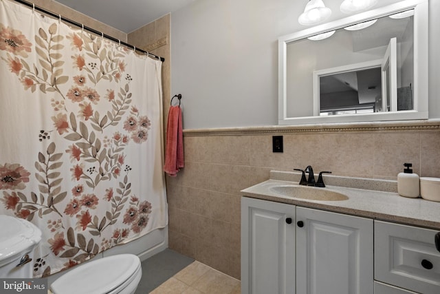 full bathroom with tile patterned flooring, vanity, and tile walls