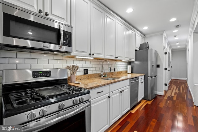 kitchen featuring stainless steel appliances, crown molding, dark wood-type flooring, sink, and white cabinets