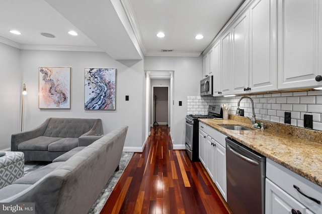 kitchen featuring appliances with stainless steel finishes, crown molding, sink, white cabinets, and dark hardwood / wood-style floors