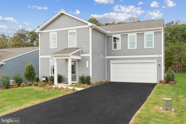 view of property featuring a garage and a front yard