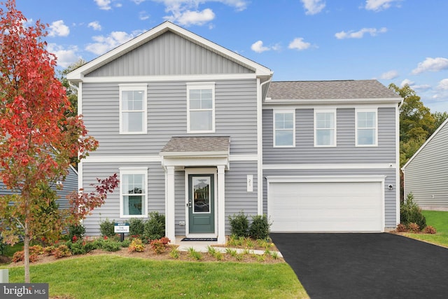 front facade with a front yard and a garage