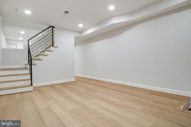 basement with light hardwood / wood-style flooring