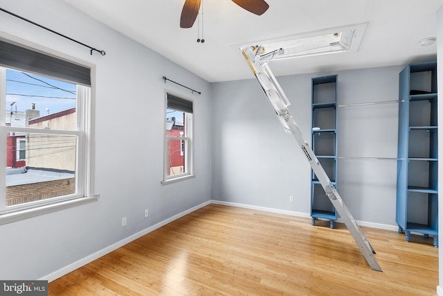 interior space with a wealth of natural light, hardwood / wood-style floors, and ceiling fan