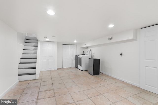 washroom featuring light tile patterned floors and washing machine and dryer