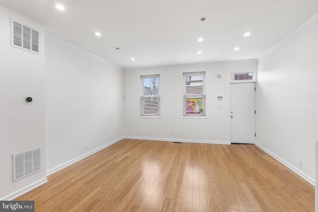 unfurnished room featuring crown molding and light wood-type flooring