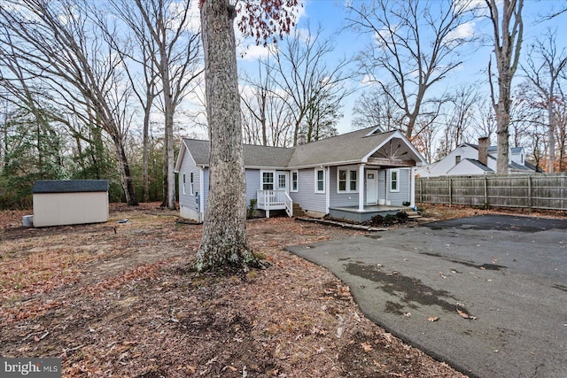 exterior space with a porch and a storage shed