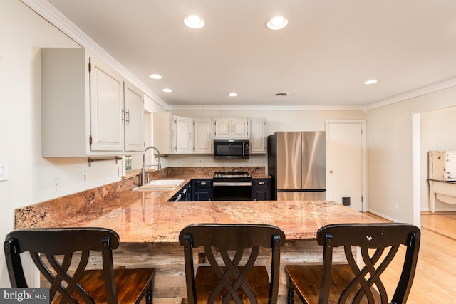 kitchen with light stone countertops, appliances with stainless steel finishes, light wood-type flooring, crown molding, and sink