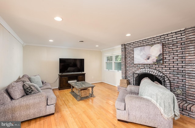 living room featuring a fireplace, crown molding, and wood finished floors