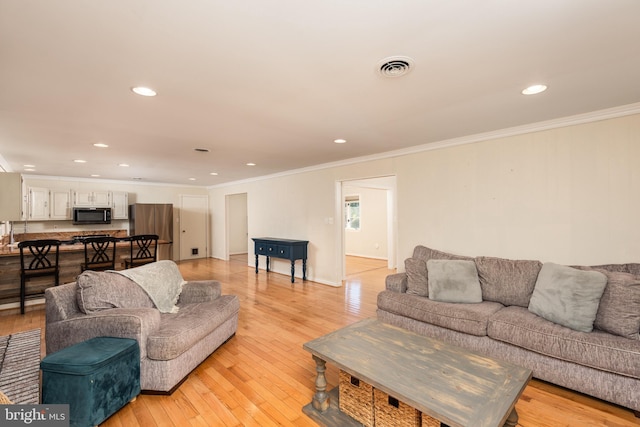 living area featuring ornamental molding, recessed lighting, visible vents, and light wood finished floors