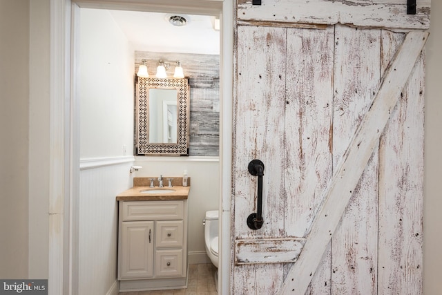 bathroom featuring toilet, wainscoting, vanity, and visible vents