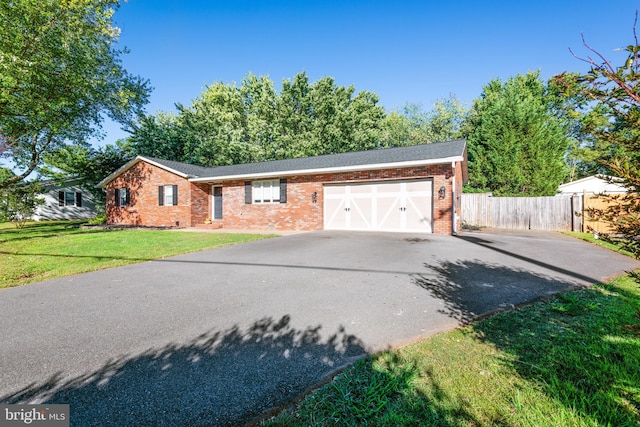 view of front facade featuring aphalt driveway, a front lawn, brick siding, and a garage