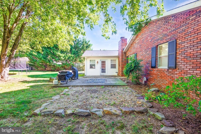 exterior space featuring a yard, a trampoline, and a patio