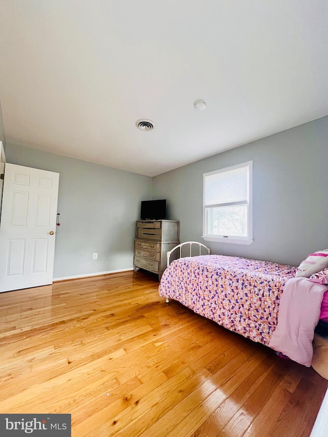 bedroom with hardwood / wood-style floors and visible vents