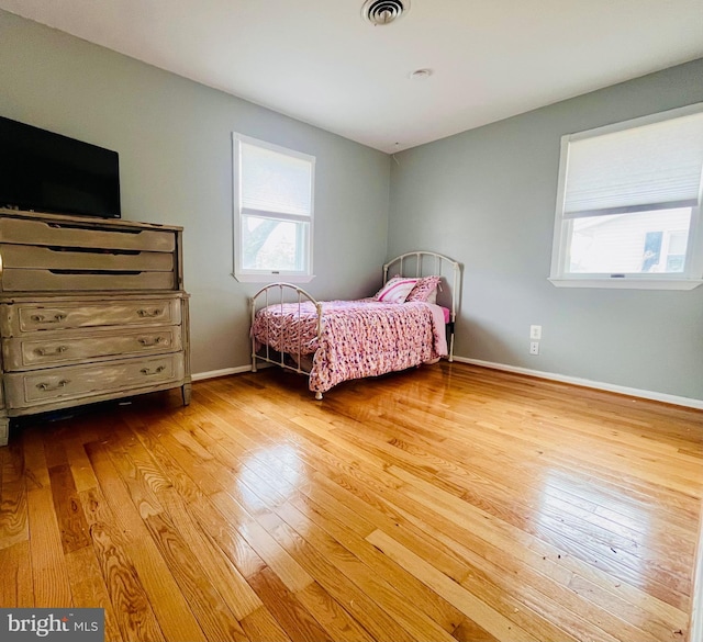 bedroom featuring baseboards, visible vents, and hardwood / wood-style floors