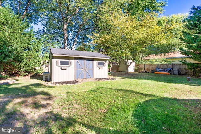 view of yard featuring an outbuilding, fence, and a storage shed