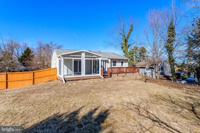 back of house with a deck, a lawn, fence, and a sunroom