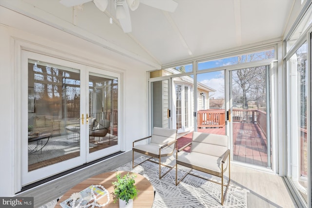 sunroom / solarium featuring vaulted ceiling, a ceiling fan, and french doors