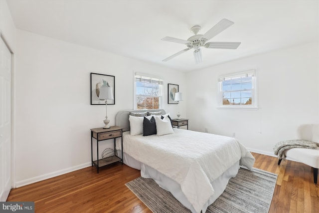 bedroom featuring ceiling fan, baseboards, and wood finished floors