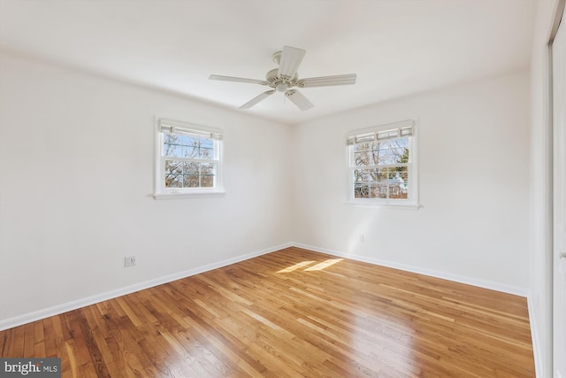 empty room featuring baseboards, ceiling fan, and light wood-style floors