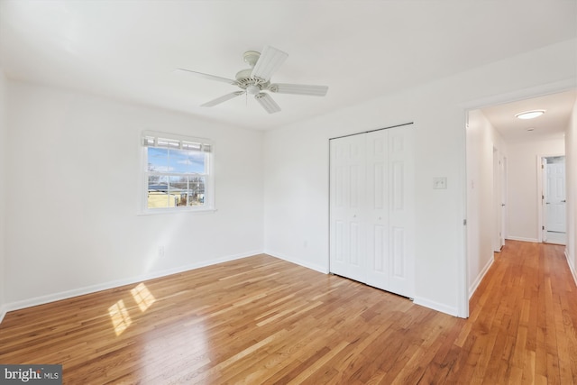 unfurnished bedroom with a ceiling fan, light wood-type flooring, a closet, and baseboards