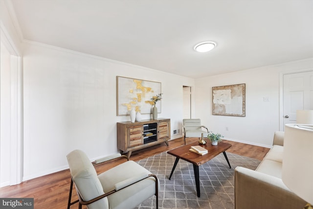 living area with ornamental molding, visible vents, baseboards, and wood finished floors