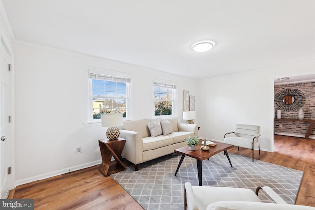 living area with baseboards, wood finished floors, and ornamental molding