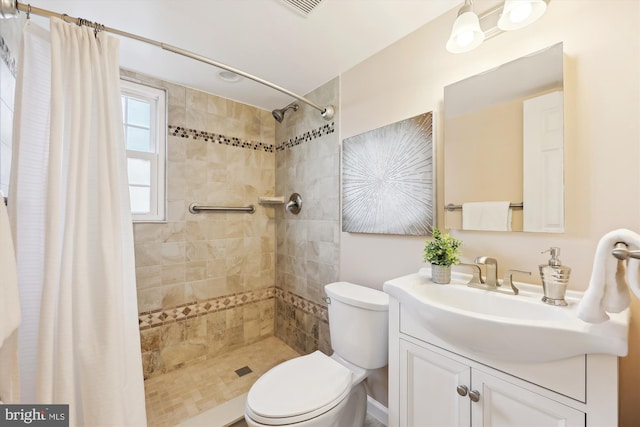 full bath featuring vanity, a tile shower, and toilet