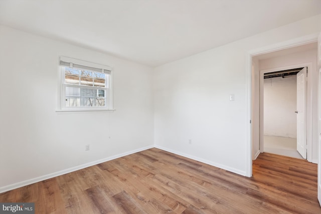 unfurnished bedroom with wood finished floors and baseboards