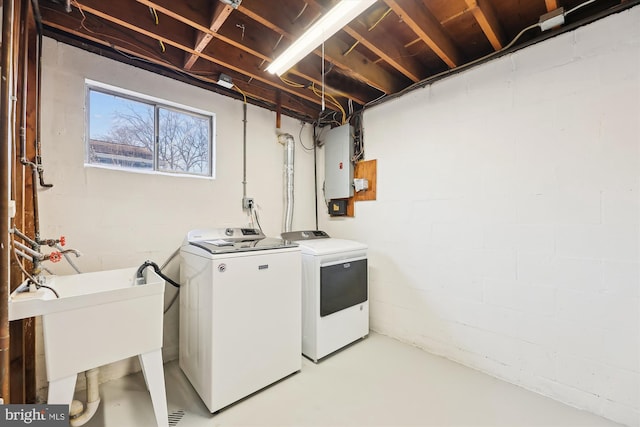 laundry area featuring laundry area, electric panel, a sink, and washer and clothes dryer