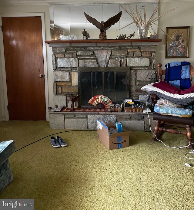 carpeted living room with a stone fireplace