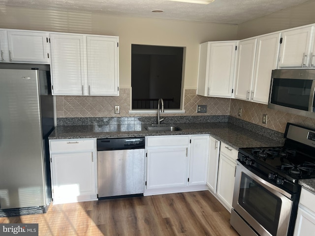 kitchen featuring stainless steel appliances, a sink, and white cabinets