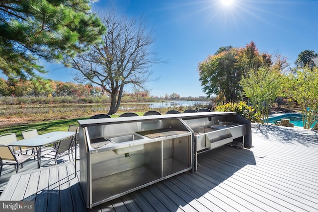 wooden deck with a water view and area for grilling