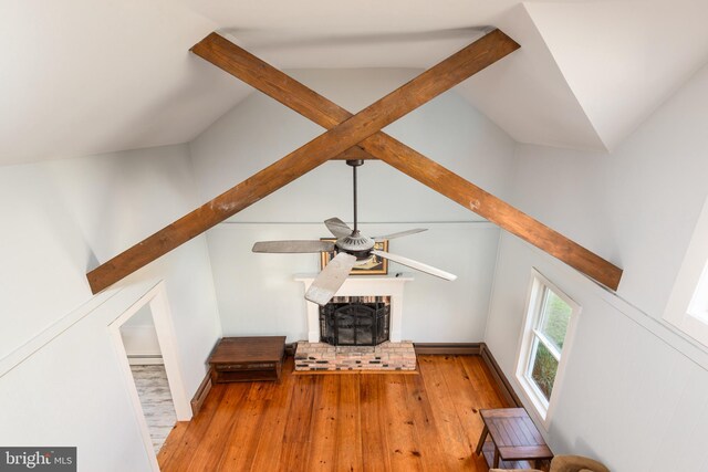 unfurnished living room featuring lofted ceiling, ceiling fan, light wood-type flooring, and a fireplace