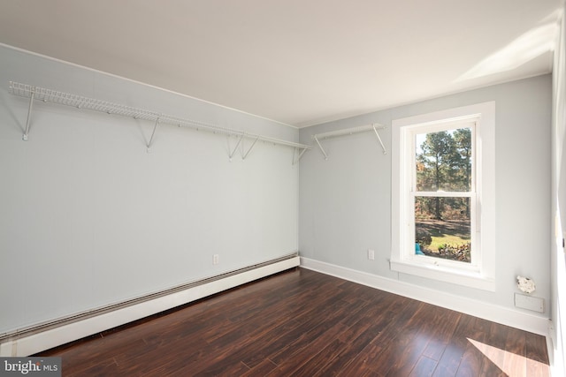 walk in closet featuring baseboard heating and dark wood-type flooring