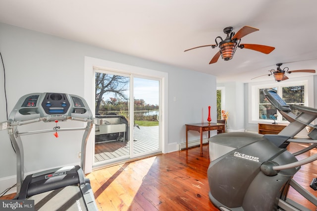 exercise room featuring ceiling fan, wood-type flooring, and a baseboard radiator