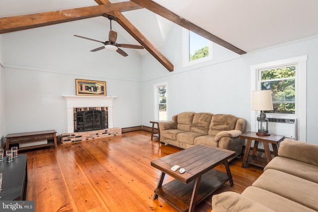 living room with ceiling fan, beam ceiling, hardwood / wood-style flooring, high vaulted ceiling, and a fireplace