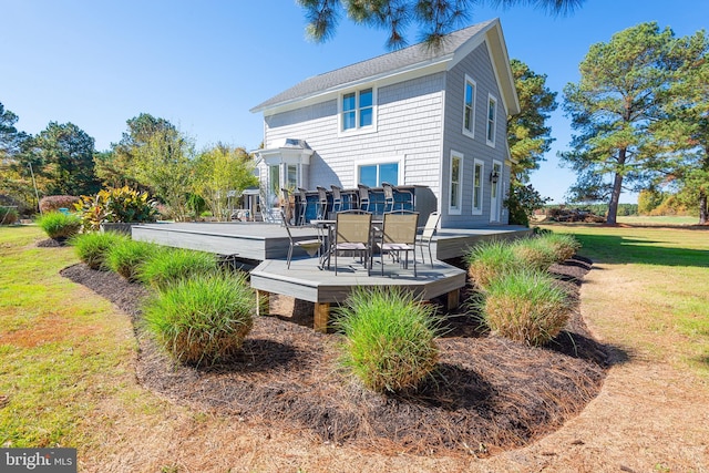 back of property with a yard and a wooden deck