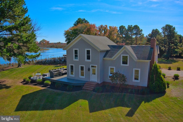 view of front of property featuring a deck with water view and a front lawn