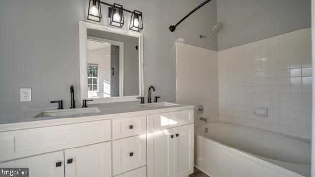 bathroom featuring vanity and tiled shower / bath combo