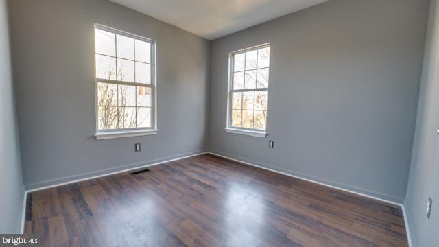 unfurnished room featuring dark hardwood / wood-style flooring